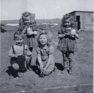 Fr. Frank making mud pies with his sisters - Vivian, Lillian, and Myrna - circa 1947.