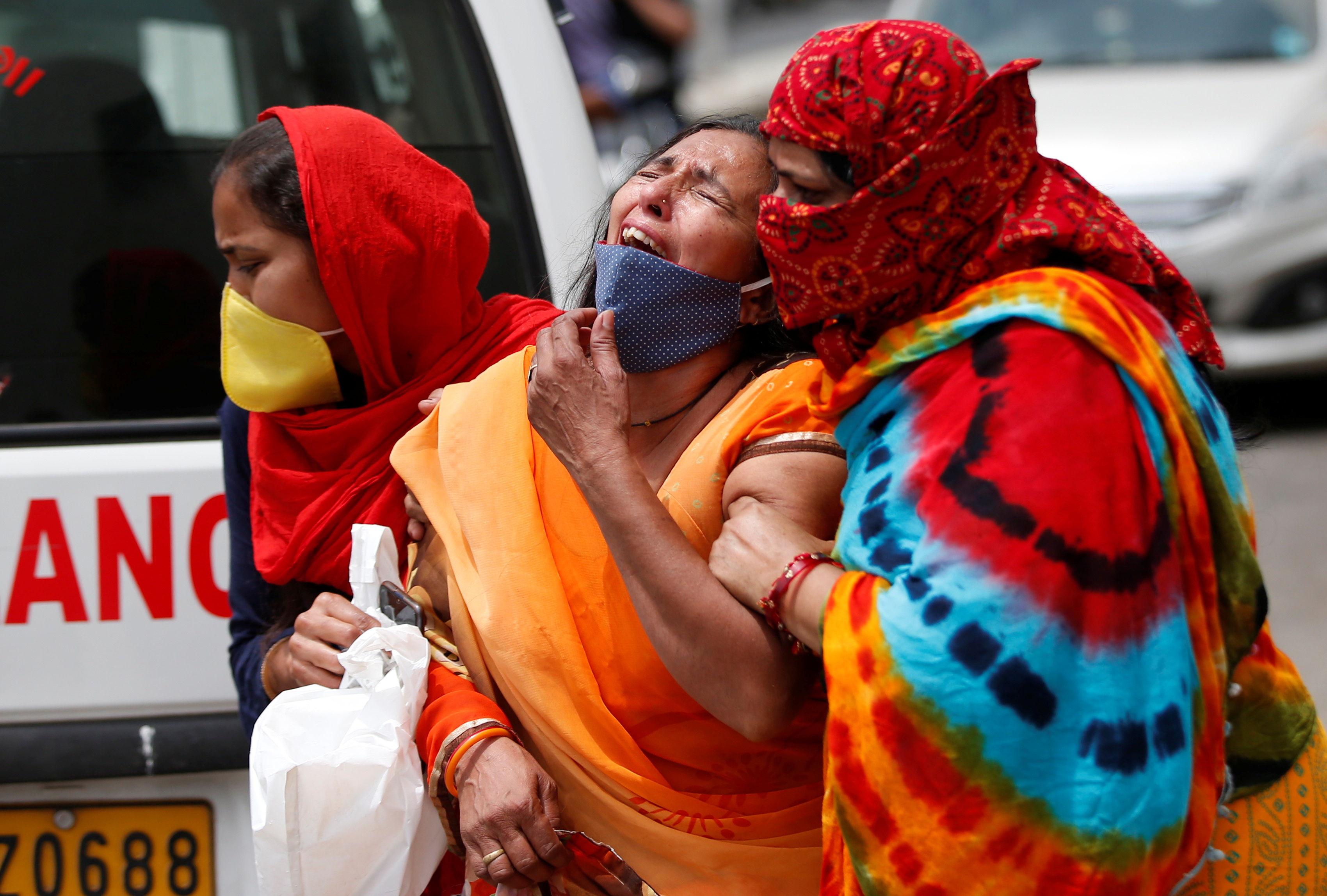 A woman is consoled after her husband died due to the coronavirus disease (COVID-19) outside a mortuary of a COVID-19 hospital in Ahmedabad, India, April 20, 2021. Source: newsindiatimes