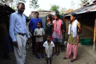 Father Thomas and Father Ekka with a family at the Tea Estates