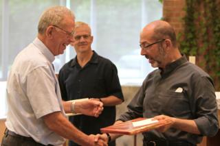 Father Provincial presenting a gift to Paul Desmarais, SJ