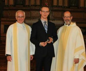 Erik Sorensen, SJ takes his first vows in the presence of Erik Oland, SJ, Novice Master and Peter Bisson, SJ , Provincial of the Jesuits in English Canada. Source: twitter.com.